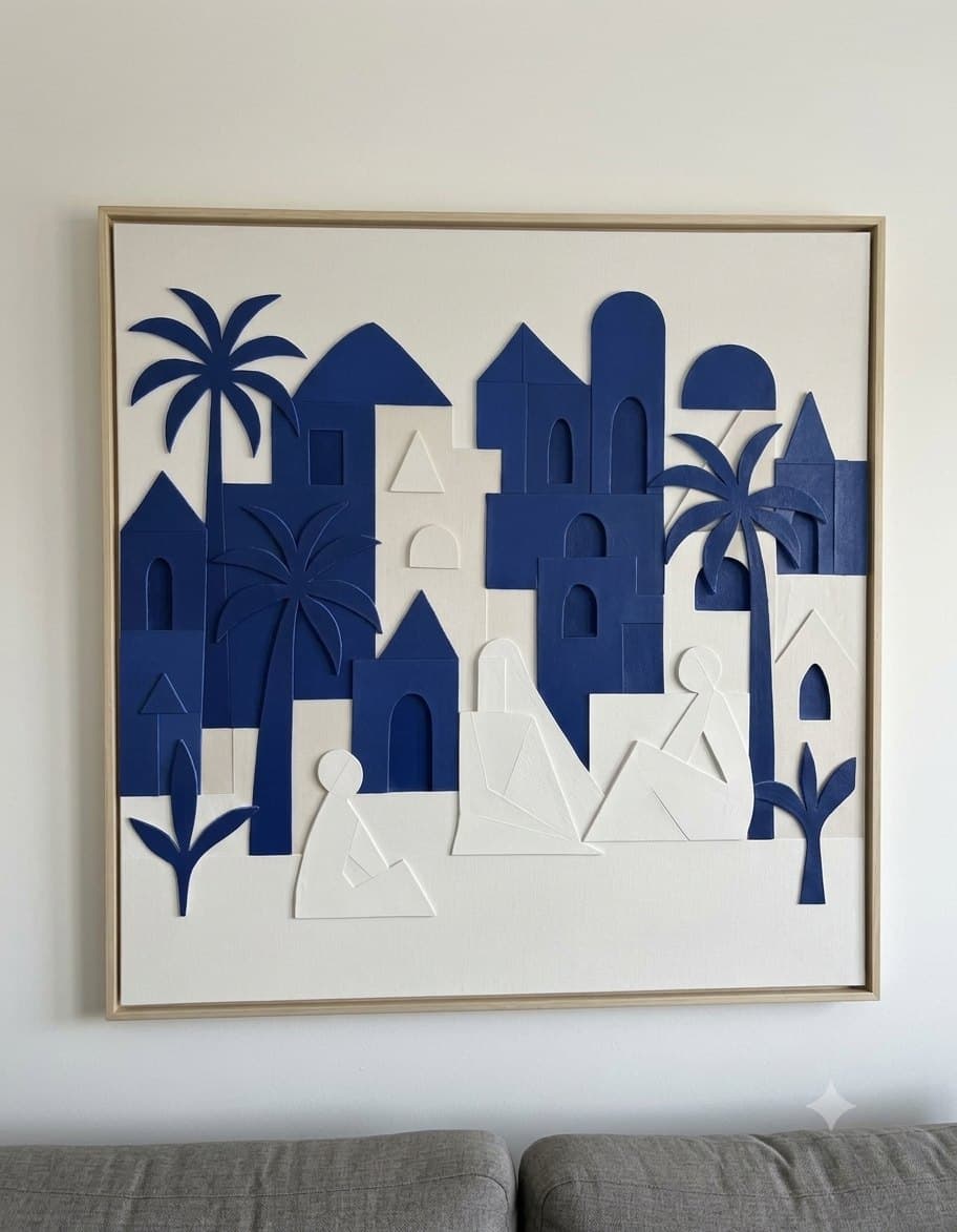 The Blue Oasis: indigo houses, arches and palm trees in raised relief on white, shown in a light wood frame